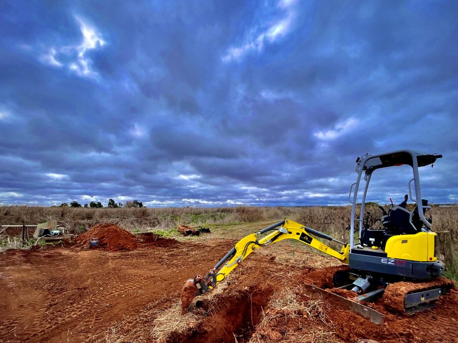 Riverina Diggers 1.7t Wacker Neuson EZ17 zero swing excavator digging a trench in red soil near Griffith NSW